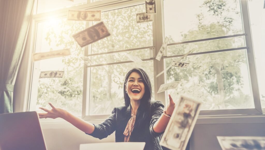 Happy businesswoman with around falling money in office - Thor Wealth Managment, Inc.