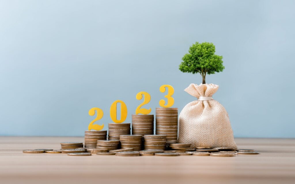 gold wooden number 2023 on a stack of coins for investment, and - Thor Wealth Managment, Inc. setting goals